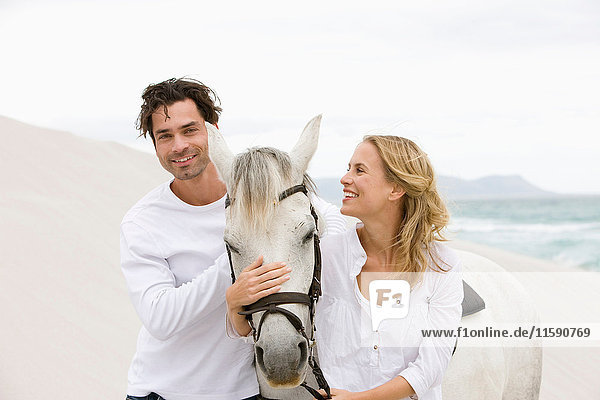Paar mit Pferd am Strand