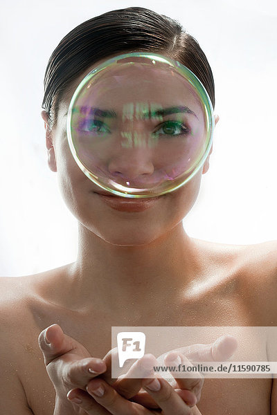 Porträt einer jungen Frau  die durch eine Blase schaut