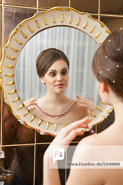Frau mit Kette vor dem Spiegel