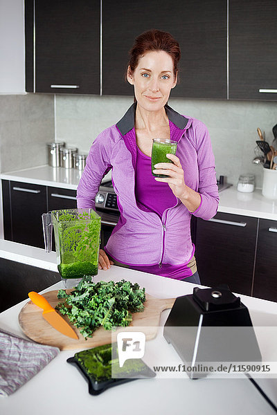 Reife Frau mit einem Glas frischem Gemüsesaft