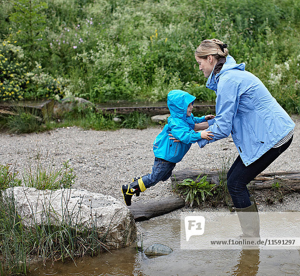 Mutter und Sohn spielen im Bach