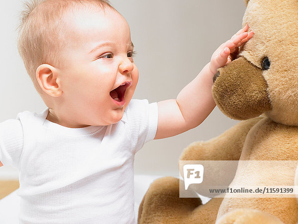 Baby spielt mit einem Teddybär
