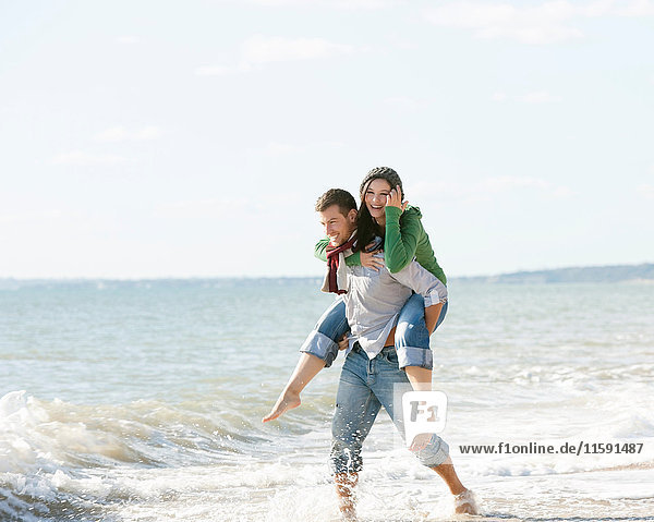 Woman riding piggyback by the sea