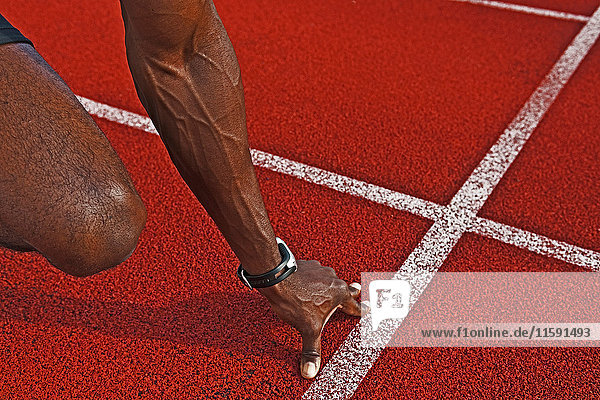 Die Hand des Sprinters an der Startlinie