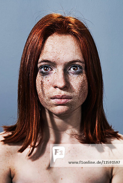Junge Frau mit verschmiertem Make-up im Gesicht