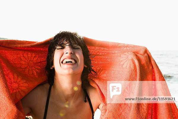 Lächelnde Frau spielt mit Handtuch