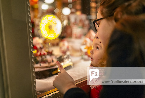 Zwei Mädchen beim Anblick eines Weihnachtsschaufensters