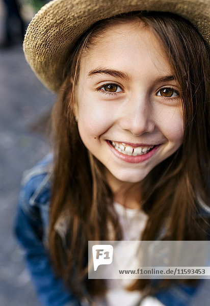 Portrait of a smiling girl wearing a hat outdoors