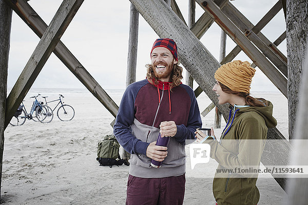 Deutschland  Schleswig-Holstein  St. Peter-Ording  Paar auf einer Fahrradtour mit Pause am Strand