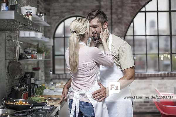 Loving couple preparing food in kitchen