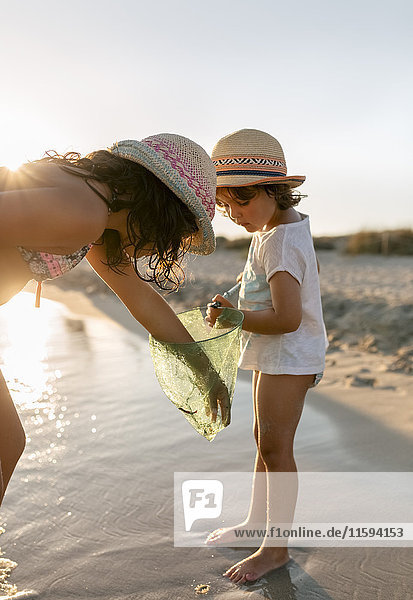 Spanien,  Menorca,  zwei Mädchen mit Dip-Netz am Strand