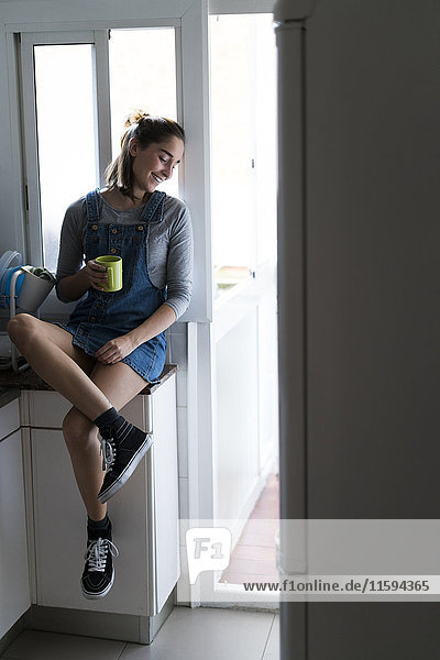 Entspannte junge Frau zu Hause bei einem Kaffee