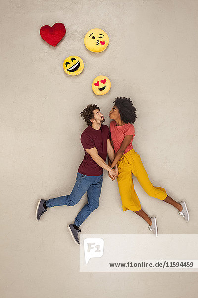 Ein glückliches Paar  das sich über den Kopf in Emojies verliebt.