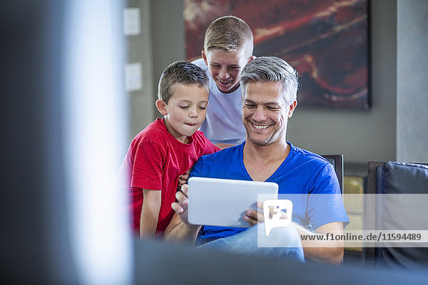 Kinder  die mit ihrem Vater auf einem digitalen Tablett suchen