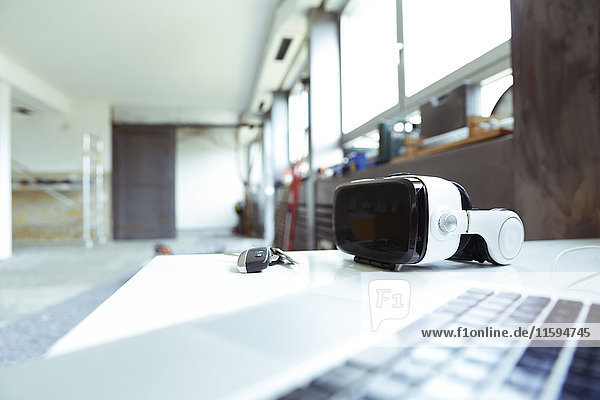 Laptop  Schlüssel und Virtual Reality Brille auf dem Tisch auf der Baustelle