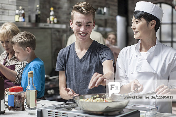 Teenager und Köchin beim gemeinsamen Kochen
