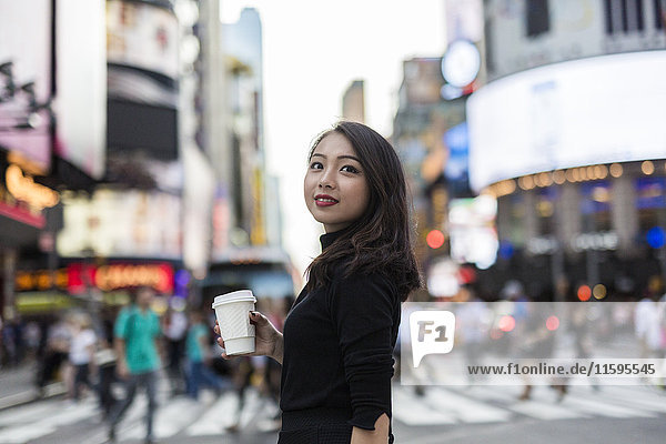 USA  New York City  Manhattan  junge Frau mit Kaffee für die Straße