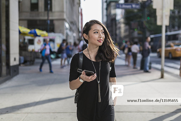 USA  New York City  Manhattan  portrait of young woman with cell phone dressed in black