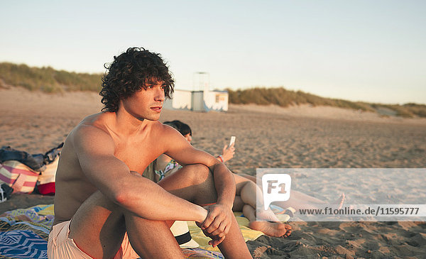 Junger Mann entspannt am Strand