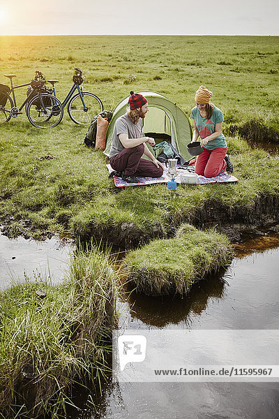 Deutschland  Schleswig-Holstein  Eiderstedt  Paar mit Fahrrädern beim Camping in Sumpflandschaft