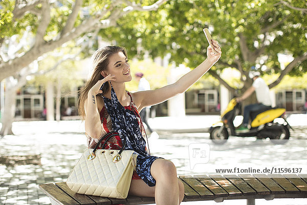 Modische Frau  die einen Selfie in der Stadt nimmt.