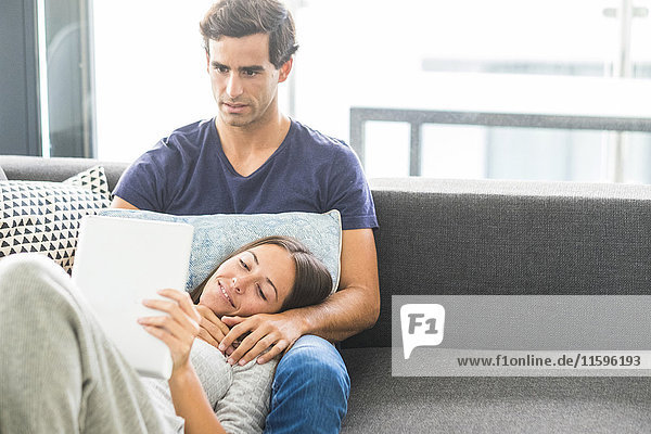 Junges Paar mit Tablette zum Entspannen zu Hause