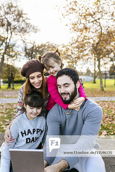 Family with tablet in autumnal park