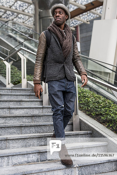 Stylish man wearing autumn fashion walking down stairs