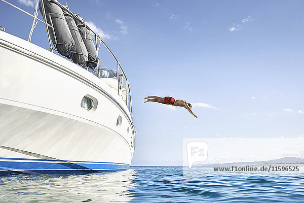 Man jumping off his motor yacht