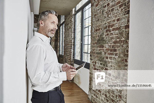Geschäftsmann mit Tablette im modernen Bürogeschoss