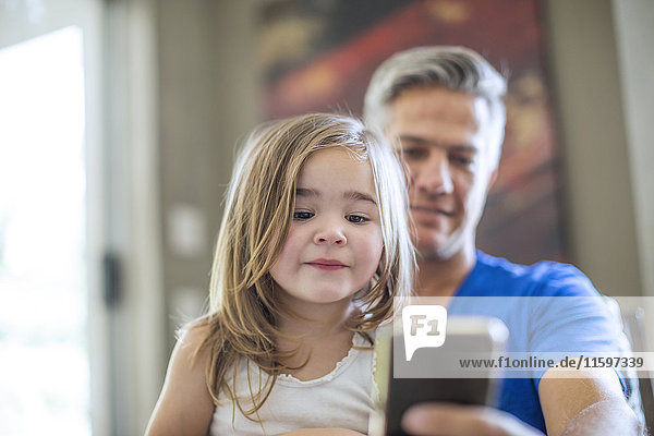 Vater und Tochter teilen sich Handy