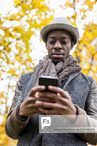 Portrait of stylish man looking at cell phone