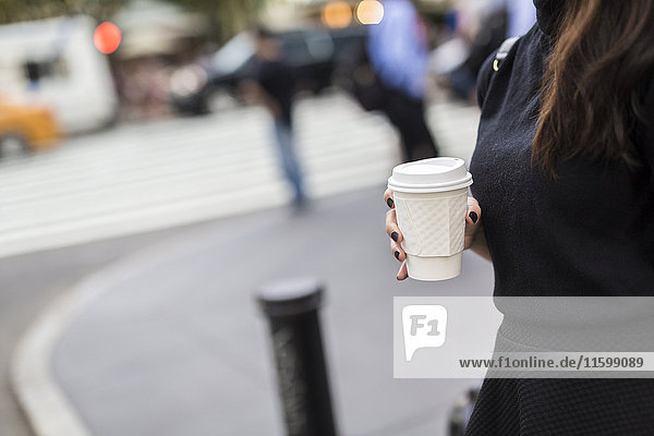 Woman with coffee to go the street  partial view