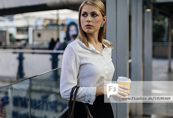 Portrait einer Geschäftsfrau mit Kaffee zum Mitnehmen