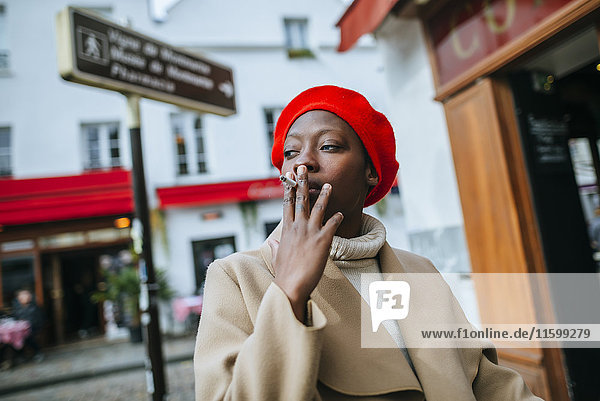 Young woman in Paris smoking a cigarette