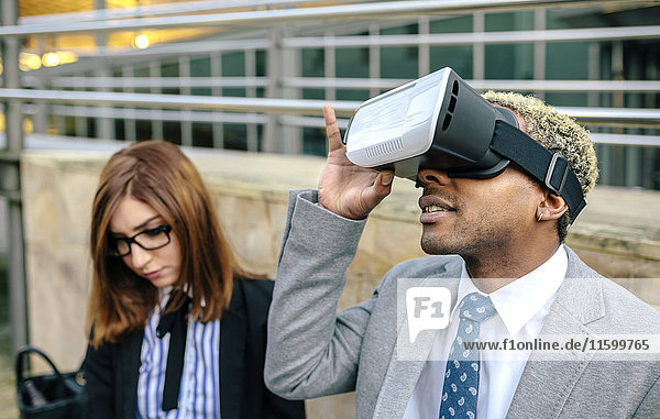 Young businessman and woman using VR goggles