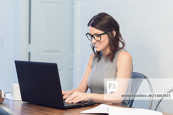 Caucasian woman wearing eyeglasses using laptop