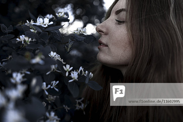 Caucasian woman smelling flowers outdoors