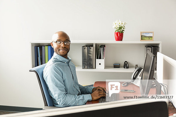 Afroamerikanischer Mann am Computer im Büro