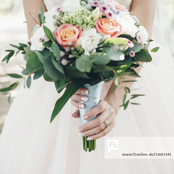 Kaukasische Braut hält Blumenstrauß