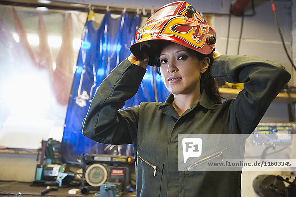 Mixed Race woman wearing protective mask in workshop