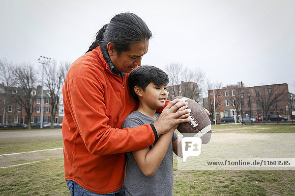 Amerikanischer Vater bringt seinem Sohn das Fußballwerfen bei