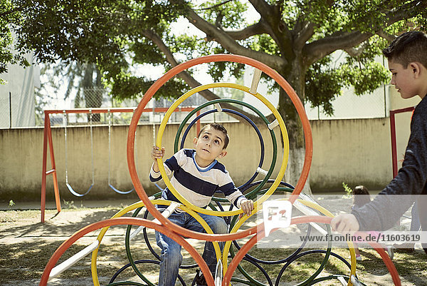 Hispanic boys climbing on structure at playground