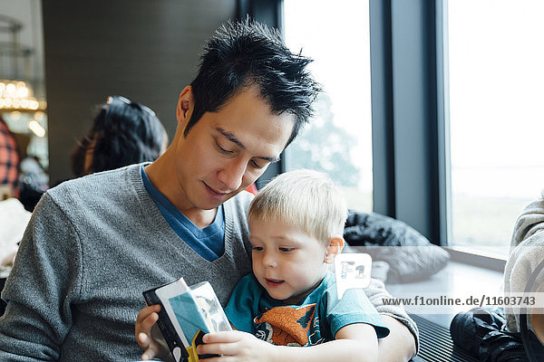 Gemischtrassiger Vater und Sohn lesen Speisekarte im Restaurant