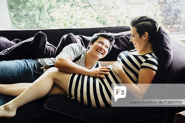 Schwangere lesbische Paar kuscheln auf Sofa