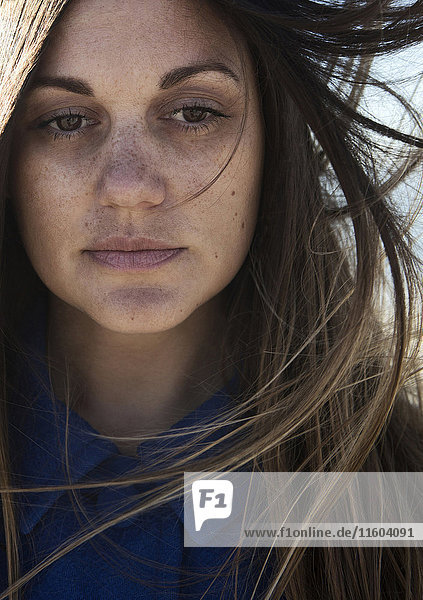 Wind blowing hair of Caucasian woman with freckles