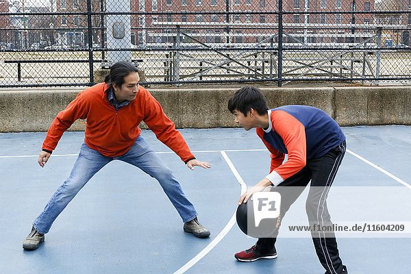 Native American father and son playing basketball