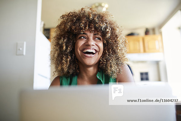 Lachende schwarze Frau mit Laptop