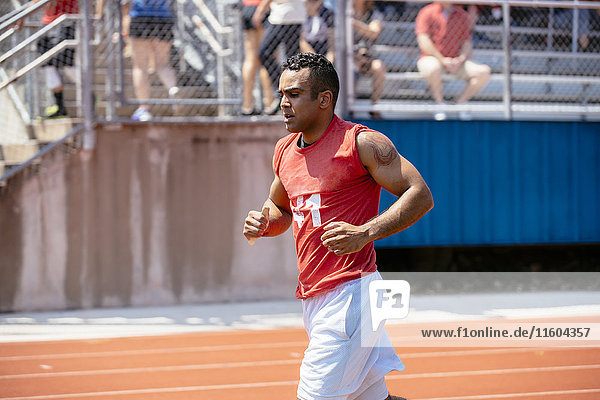 Hispanic man running on track