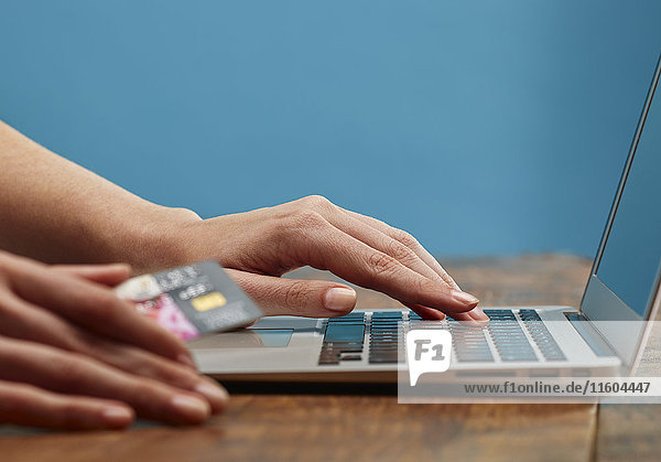Hände einer Frau beim Online-Shopping mit Laptop